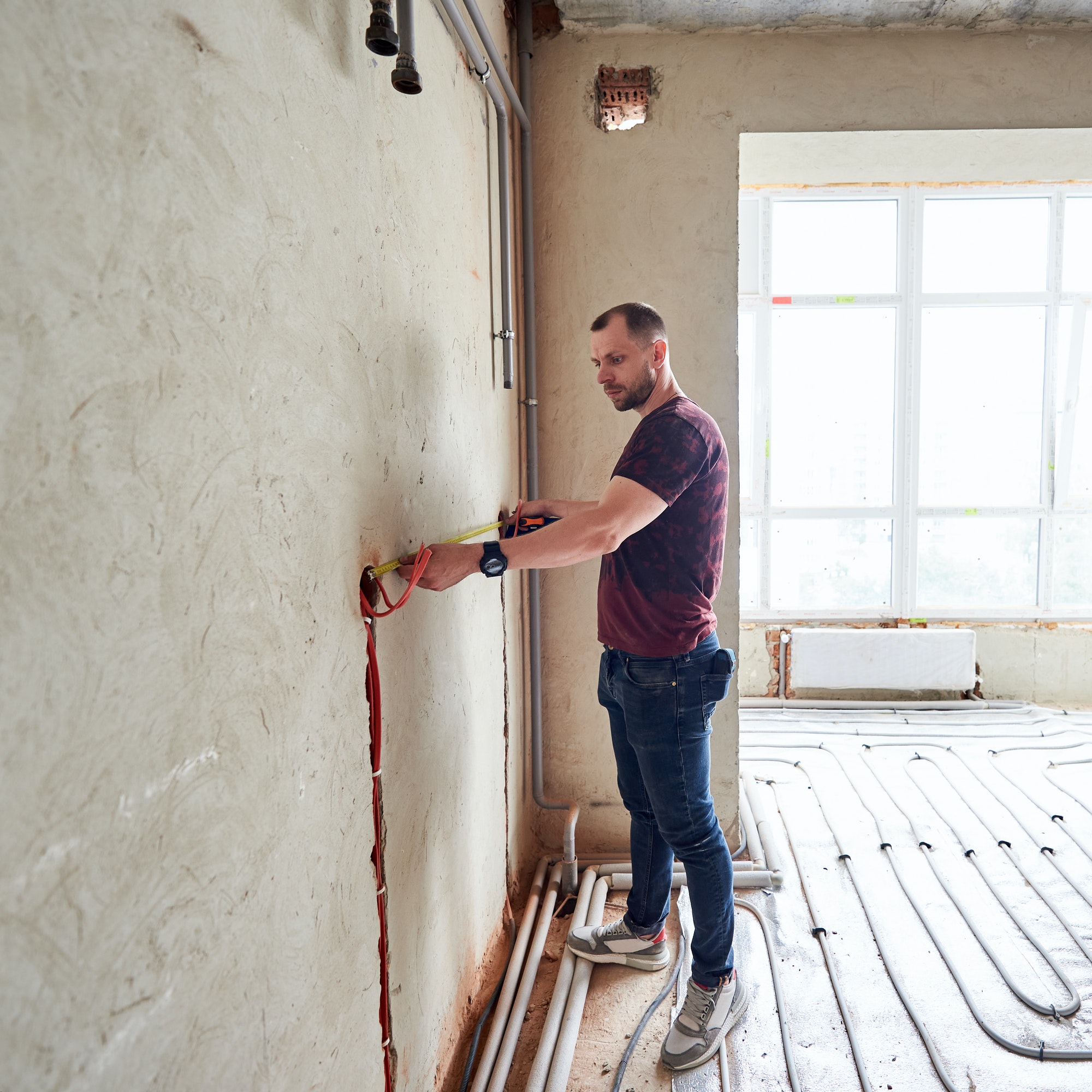 Professional technician measuring the wall in new apartment